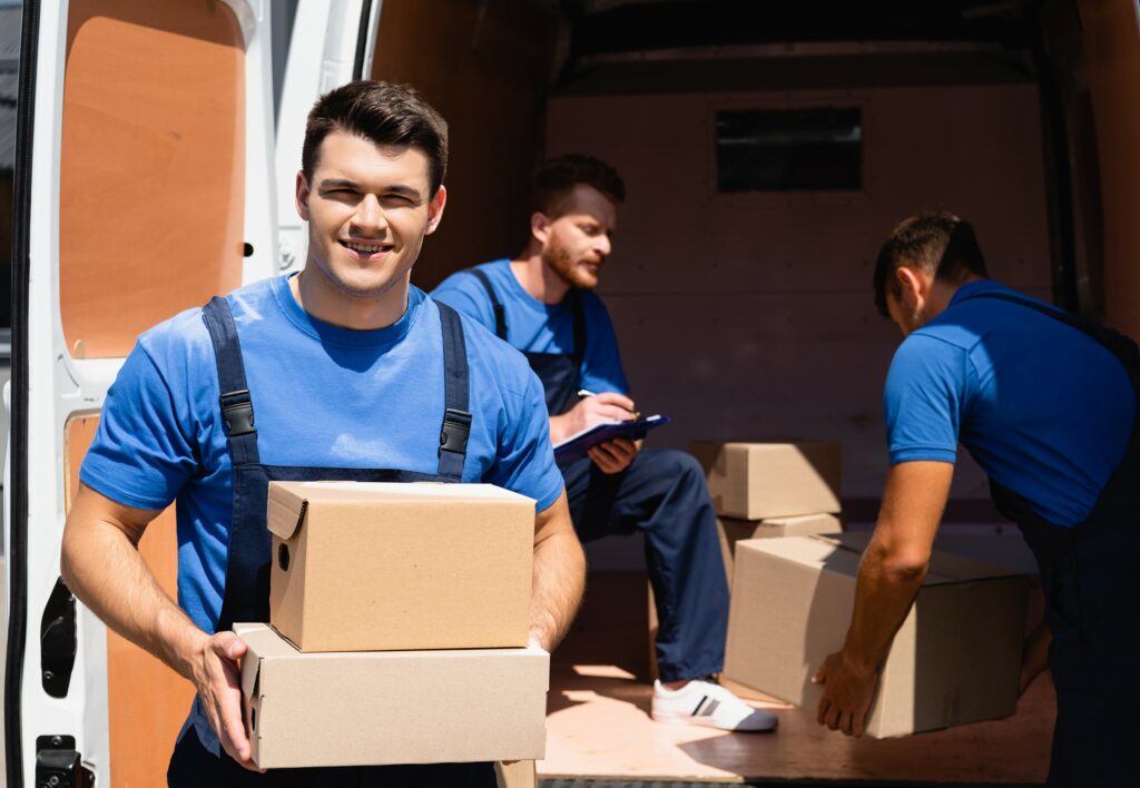 Mitarbeiter packen Kartons in einen Transporter