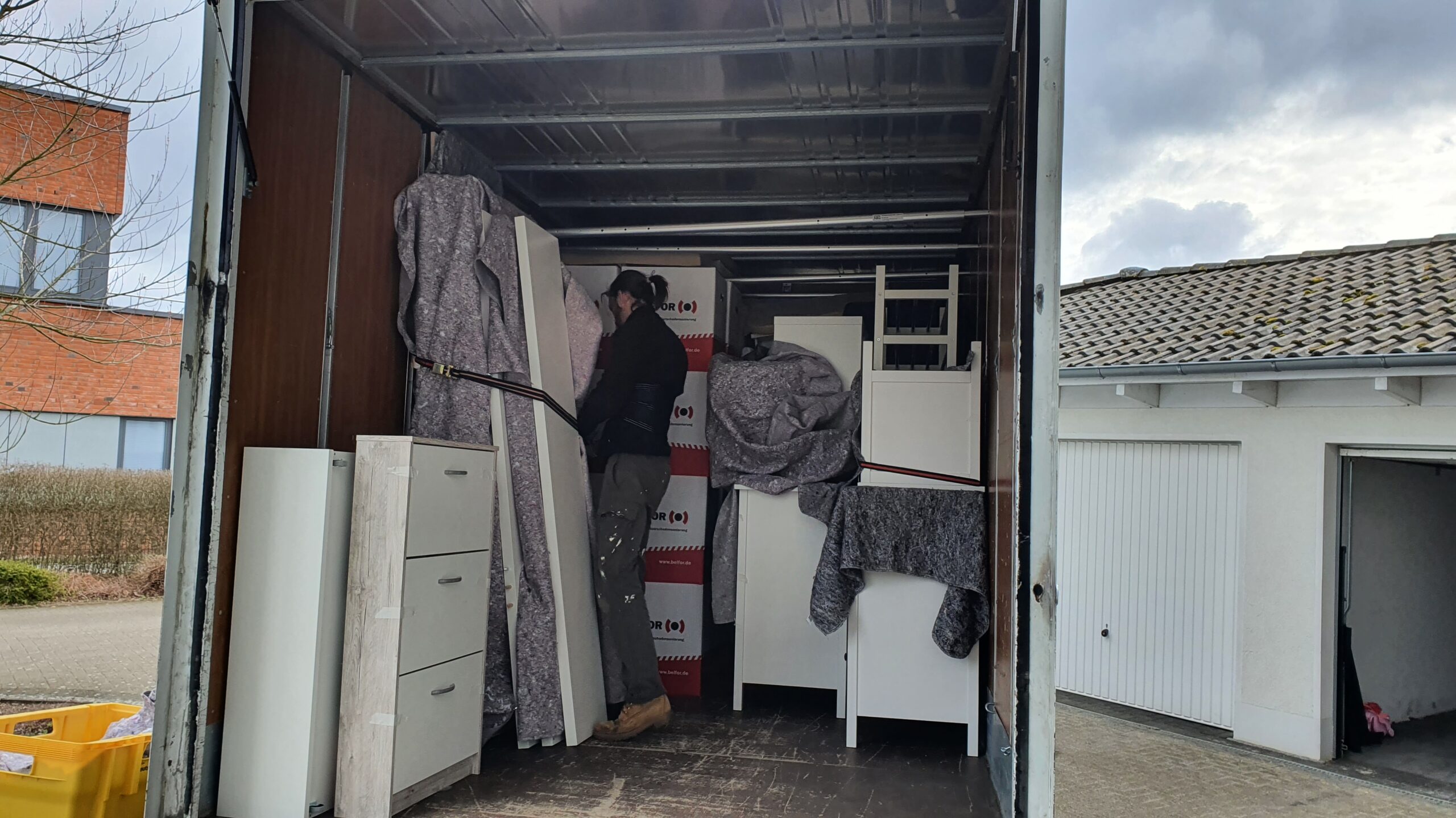 Transporter beladen mit Möbeln und Kartons von einem professionellen Mitarbeiter