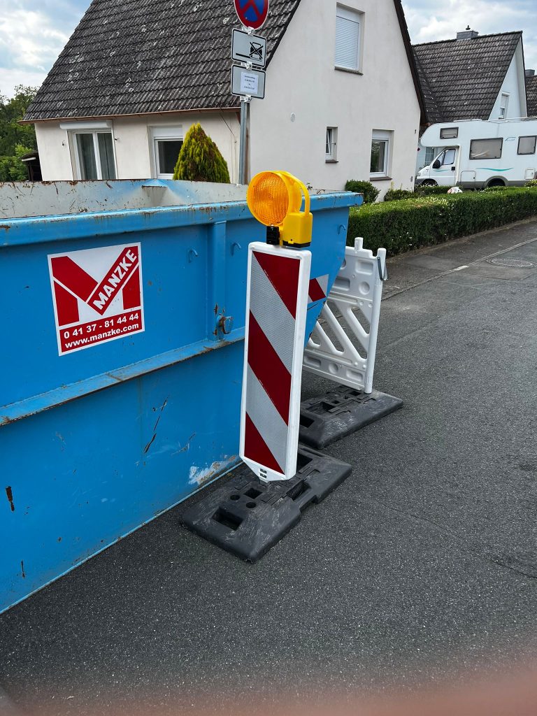 Container auf einer Straße mit korrekter Absperrung